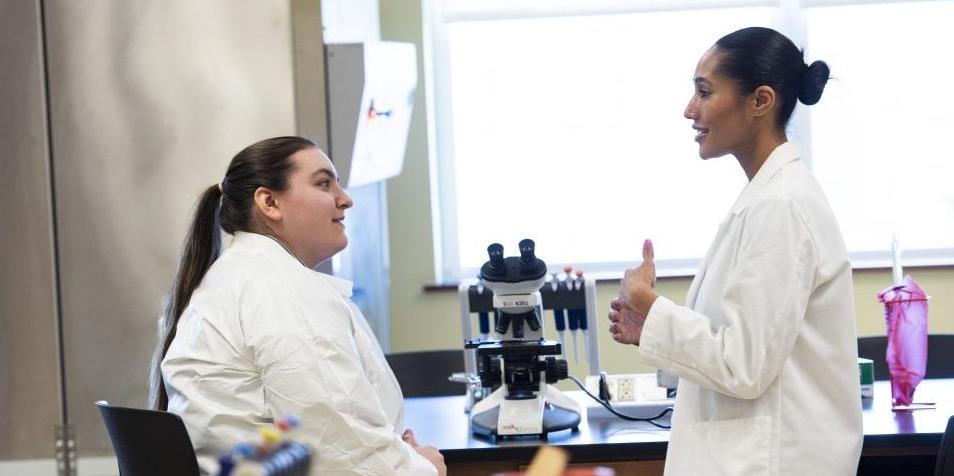 Two individuals in labcoats with equipment